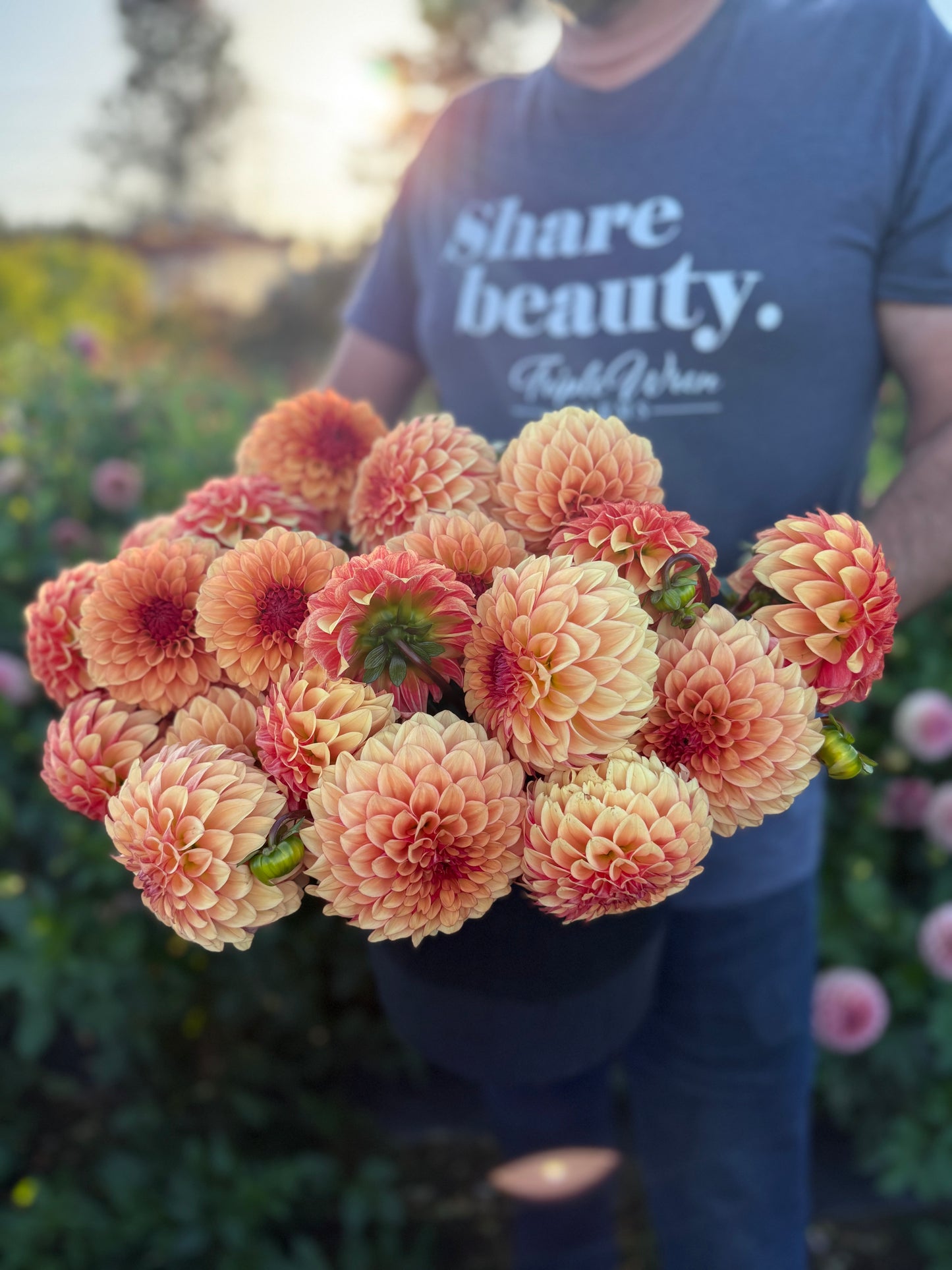 Person holding a bouquet of flowers with 'Share beauty' t-shirt in the background