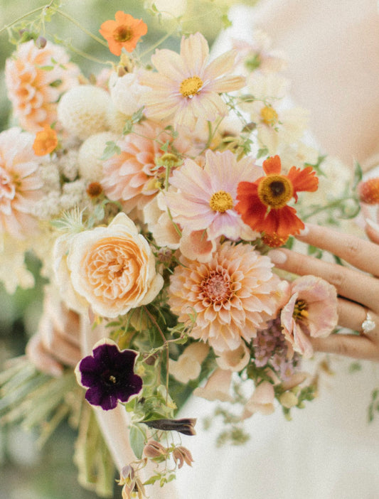 Close-up of a bouquet with various flowers including roses and dahlias.